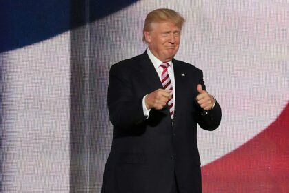 Donald Trump beside man in black suit