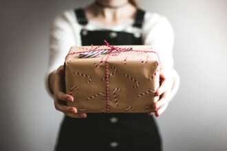 person showing brown gift box; high impact corporate gifting