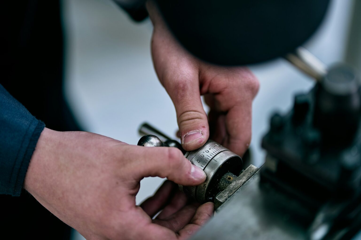 Hands manipulate a metal device on a table.; mechanical pump seal